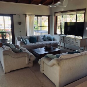 lounge opens onto deck to capture breezes Seating for 9  with big screen tv