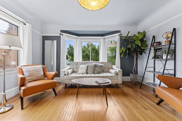 Living room oasis: plush couch, comfy chairs, and leafy green friend.