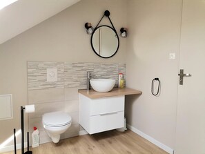 Salle d'eau avec lavabo et toilettes