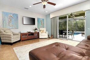 The living room has the main doors to the lanai and pool deck.