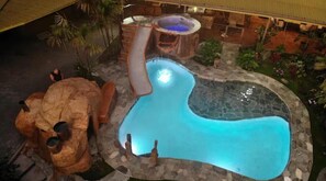 Aerial view of pool, jacuzzi, waterslide and cave