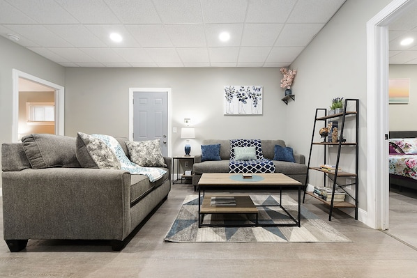 The living room features cozy furniture, ample natural light, and modern decor.