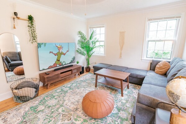 Main living room features a 65" flat screen tv and comfortable sectional couch.