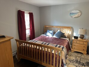 Master bedroom queen bed and night stand.