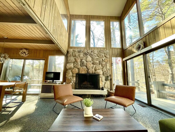 Welcome to your main living area, filled with soaring windows and a fireplace