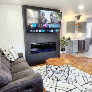 Cozy Living Room with a 70" smart TV, recling sofas, &  fireplace. 