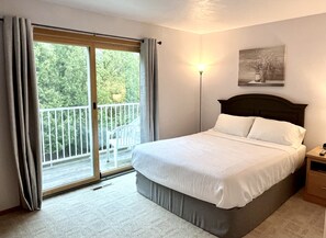 Second floor master bedroom with queen bed, TV, balcony, vanity and sink