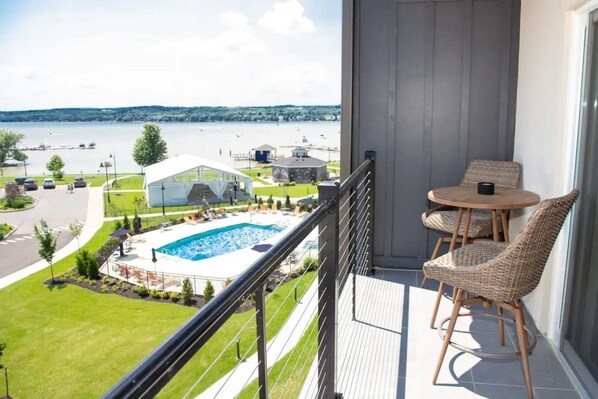 The open wrap around porch offers seating for two, a coffee table, and panoramic views of Canandaigua lake. Perfect for morning coffee or unwinding in serenity.