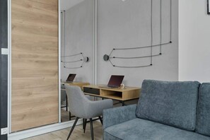 A comfortable seating area with a blue sofa, a wooden coffee table, and decorative wall hangings, blending contemporary and rustic elements.