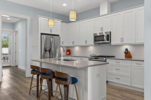 The kitchen is a modern space with sleek countertops, stainless steel appliances, and ample storage, perfect for culinary creativity and gatherings