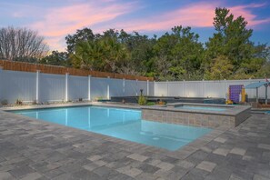 Relaxing poolside sanctuary featuring a luxurious spill-over pool, offering the ultimate indulgence in comfort and tranquility