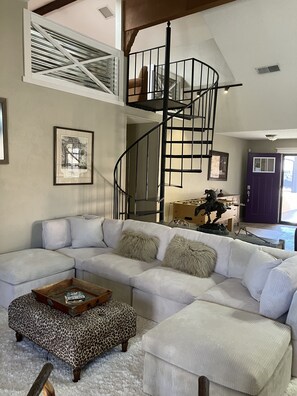 Large main living space with spiral staircase up to loft