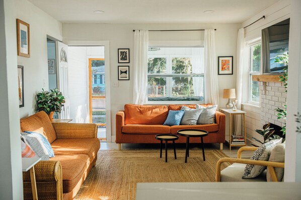 The spacious living room features a large smart TV with Netflix + Prime Video subscriptions, an Echo Pop speaker, electric fireplace, and two sofas and chair for lounging. We also provide board games. 