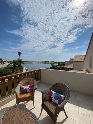 Terrasse de la chambre 3 avec son salon en osier et vue mer et lagune…