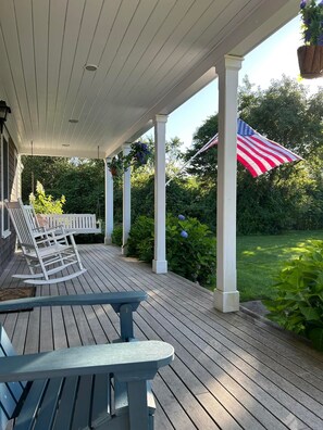 Beautiful covered front porch with Adirondacks , and porch swing to watch sunset