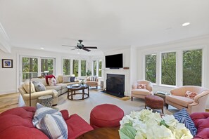 Spacious First Floor Living Room with Comfortable Seating, TV, and Lots of Windows and Natural Light