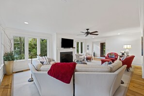Spacious First Floor Living Room with Comfortable Seating, TV, and Lots of Windows and Natural Light