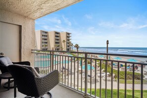 Relax on the covered balcony with view of Ocean, Beach and pool area.