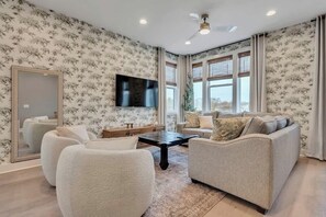 The living room features plenty of comfy seating and a large SmartTV for easy login to all your streaming services.
