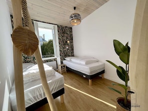 Chambre 3: Très lumineuse, équipée de deux lits de 80/200, convertible en 160/200, de deux tabourets de chevet, d'un joli portant à vêtements en bois et de deux appliques murale.