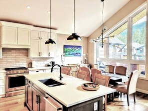 Open concept kitchen with island seating and local Canmore artists work.