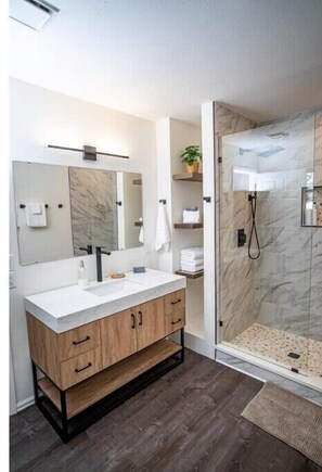 Newly remodeled ensuite with walk-in tiled shower and marble vanity.