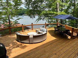 Expansive new deck with large couch, propane firepit and 8-person dining table.