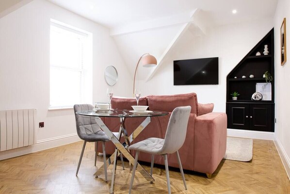 Large living area with dining table and large smart tv.