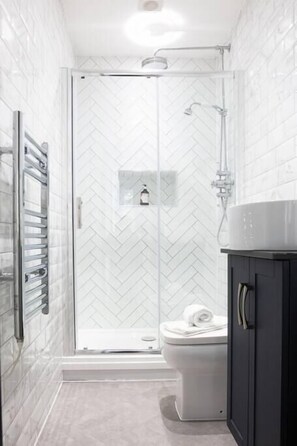 Bathroom with rainfall shower and vanity unit.