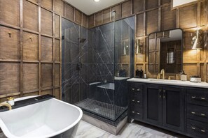 Wood Paneled luxury. Soaking tub along with glassed in bathroom. This is bathroom number 2, also located on the main floor. Complimentary bath salts and custom Hollyhock shampoo and body wash!