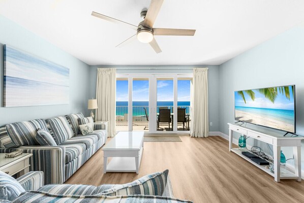 Unwind in a bright and airy living room featuring a queen-size sleeper sofa, a smart TV, and stunning ocean views through floor-to-ceiling windows leading to a private balconyUnwind in a bright and airy living room featuring a queen-size sleeper sofa, a s