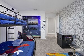 Step into a playful Mickey-themed loft where gaming and comfort collide. Featuring a bunk bed, cozy gaming setup, and vibrant decor, this room is a dream for kids and gamers alike, promising fun-filled days and restful nights at Storey Lake.