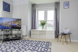 Contemporary living room featuring a comfortable sofa, entertainment center, and serene decor.
