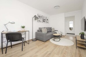 Another angle of the living room, highlighting the open layout, a reading nook, and contemporary furniture.

