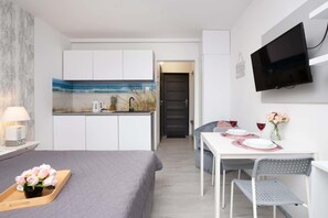 Another view of the bedroom, showing a modern TV, and a bright interior with stylish decor.

