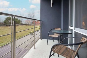 A private balcony with a small table and two chairs, offering a peaceful outdoor space with a view of the surroundings.

