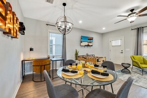 Natural light spills in through nearby windows, casting a gentle glow over the elegant 4-seater table and creating a warm and inviting ambiance.