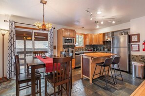Fully equipped kitchen has dining table for 8 plus stools at the kitchen island.