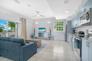 A bright and spacious sitting area with a cozy sofa and a Smart TV