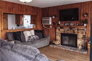 Living room. Has couch, reclinable love seat, fireplace, smart TV and cable.