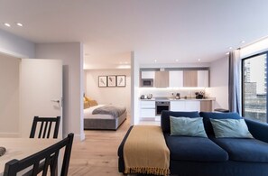 Integrated living, bedroom, and kitchen spaces in an open layout.