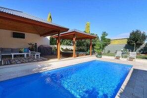 Outdoor area with swimming pool, dining room and hot tub