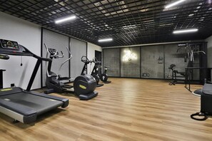 A well-equipped gym with treadmills, stationary bikes, and weight training equipment, offering a convenient fitness space.

