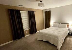 Master bedroom with blinds and black-out curtains.