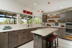 Full kitchen with island providing additional seating and views of the backyard and beyond