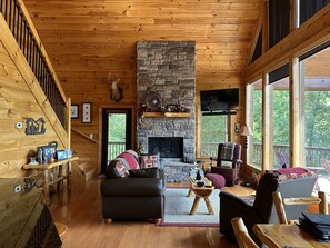 Gas fireplace and floor to ceiling glass windows with mountain views