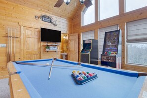 Game room features a pool table, TV, and arcade games.