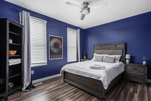 Enter this stylish room featuring deep blue tones, sleek modern decor, and a striking black bookshelf that adds both function and flair.