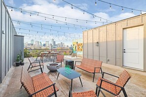 You’ll want to take full advantage of this rooftop patio, offering beautiful sky views, a BBQ grill, outdoor dining, twinkling string lights, and a cozy fire pit!