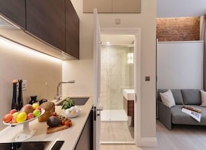 Open space with private kitchen area fully equipped with washing machine-dryer, oven-microwave, stove, kettle, toaster, Nespresso coffee machine, and kitchenware. Salt and pepper included. Non-included oils or food.
